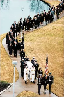  ?? JEFF ROBERSON/GETTY ?? The flag-draped casket of former President George H.W. Bush is carried by a joint services honor guard followed by family members Thursday in College Station, Texas.