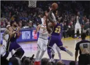  ?? MARK J. TERRILL — THE ASSOCIATED PRESS ?? Mark J. TerrillLos Angeles Lakers forward LeBron James (23) shoots and scores as Denver Nuggets forward Torrey Craig, second from right, defends and center Nikola Jokic, center, watches along with Lakers center JaVale McGee, left, during the first half of an NBA basketball game Wednesday in Los Angeles. With that basket, James moved past Michael Jordan for fourth place on the NBA career scoring list.