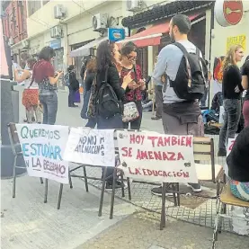  ??  ?? Sentada. En la esquina del colegio Belgrano, que ayer fue amenazado.