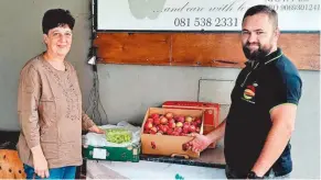  ?? ?? Gerhard van Vuuren from Vrugte Uit Die Boord hands over a donation of fruit to Walk in Faith founder Merinda Ackerman