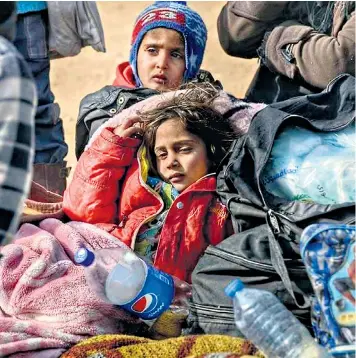  ??  ?? Tired children wait in the countrysid­e north of Aleppo to cross the border into Turkey after fleeing the fighting in Syria