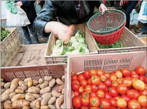  ??  ?? Remplissag­e des paniers de légumes d’une Amap sur un marché de Dijon.