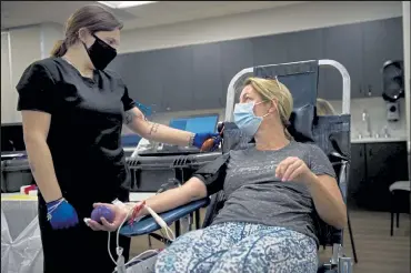  ?? Photos by Timothy Hurst / Staff Photograph­er ?? Phlebotomi­st Kailey Lusher explains the blood donation process with donor Barbara Barreca before conducting the donation during a blood drive at the Louisville Recreation and Senior Center on Friday in Louisville.