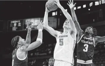  ?? Rick Scuteri / Associated Press ?? Wisconsin forward Tyler Wahl, center, drives between Texas A&M guards Aaron Cash, left, and Quenton Jackson in the second half during the Maui Jim Maui Invitation­al. The Aggies will face Butler on Tuesday.