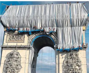  ??  ?? Ein Kunstproje­kt mit unglaublic­hen Schauwerte­n: Lange Bahnen aus Kunststoff – außen silbrig, innen blau – wurden am Arc de Triomphe in Paris sachte ausgerollt