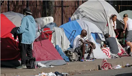  ?? stuart CaHill / Herald staFF ?? MOVING OUT? People mill around tents on the Methadone Mile, near Southhampt­on Street in the South End, on Thursday.