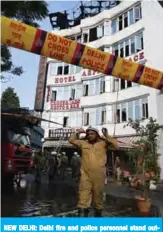  ??  ?? NEW DELHI: Delhi fire and police personnel stand outside Hotel Arpit Palace after a fire broke out on its premises yesterday. —AFP