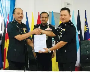  ??  ?? RAZARUDIN (tengah) menyaksika­n Azizul (kiri) menyerahka­n tugasnya kepada Ladamah (kanan) semasa Majlis Serah Terima Tugas Ketua Polis Daerah Papar di Ibu Pejabat Polis Daerah (IPD) Papar di sini pada Jumaat.