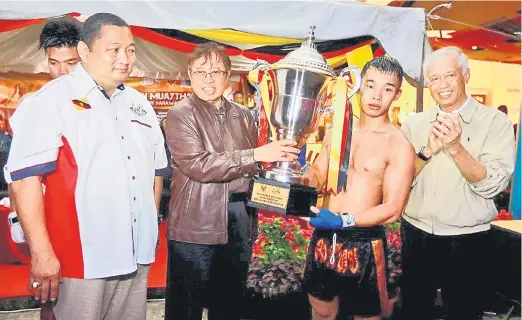  ??  ?? TAHNIAH: Abang Johari menyampaik­an Piala Ketua Menteri Sarawak kepada Morris pada Kejohanan Muaythai Sarawak di Kuching, malam kelmarin. Turut kelihatan, Abang Abdul Wahap dan Jumaat (kiri).