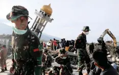  ??  ?? SOLDIERS and rescue members try to find bodies from last month’s earthquake in the Balaroa neighbourh­ood in Palu, Sulawesi island, Indonesia, yesterday.