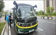  ?? YANG BO / CHINA NEWS SERVICE ?? Passengers board a QCraft unmanned bus in Suzhou, Jiangsu province, in June.