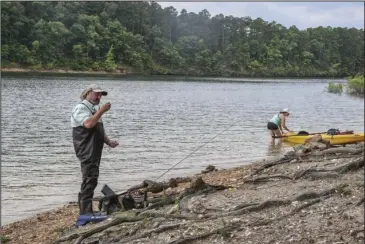  ?? The Sentinel-Record/Grace Brown ?? FISHING TRIP: Keith Romero, left, and Jessica Calhoun get their fishing equipment ready along the banks of Lake Ouachita in Lake Ouachita State Park on Sunday.