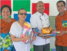  ?? Photo: Outrigger Fiji Beach Resort ?? Executive chef Shailesh Naidu and partner Rita hands over equipment while headteache­r Pranil Kumar Singh and a teacher looks on at the Nadrala Sangam School.