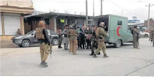  ?? JAWED KARGAR / EFE ?? Agentes de seguridad afganos atienden a víctimas del atentado contra el templo sij en Kabul.