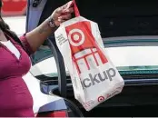  ?? Rogelio V. Solis / Associated Press ?? A Target employee places a curbside pickup purchase into the trunk of a customer in Jackson, Miss. Shopping overall is down this season.