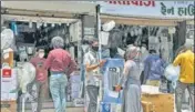  ?? ANI ?? ■
People stand outside an electronic­s shop in Surat on Tuesday.