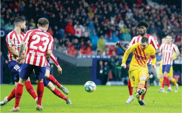  ?? Associated Press ?? ↑
Barcelona’s Lionel Messi scores against Atletico Madrid during their Spanish League match in Madrid on Sunday.