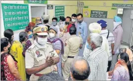  ?? SAMEER SEHGAL/HT ?? Cops urge people to maintain discipline at a vaccinatio­n site in Amritsar on Monday.