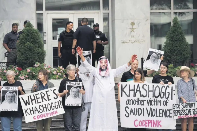  ??  ?? People, including a demonstrat­or dressed as Crown Prince Mohammed bin Salman with blood on his hands, protest outside the Saudi Embassy in Washington, DC, Oct. 8, demanding justice for Jamal Khashoggi.