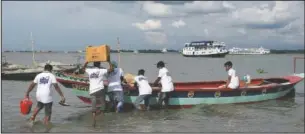  ??  ?? Volunteers load medical supplies to be carried on the boat hospital in Chandpur district.