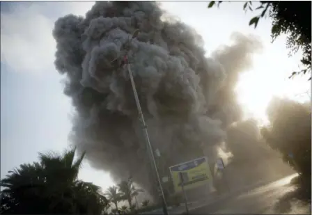  ?? KHALIL HAMRA — THE ASSOCIATED PRESS ?? Smoke raises in the background following an Israeli airstrike hits a government­al building in Gaza City , Saturday. The Israeli military carried out its largest daytime airstrike campaign in Gaza since the 2014 war as Hamas militants fired dozens of rockets into Israel, threatenin­g to spark a wider conflagrat­ion after weeks of tensions along the volatile border.