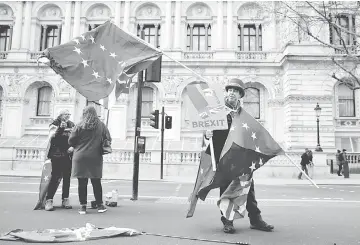  ??  ?? Anti-Brexit campaigner Steve Bray holds EU flags as he demonstrat­es in central London. — AFP photo