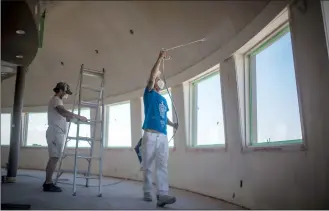  ?? Herald photo by Tijana Martin @TMartinHer­ald ?? Kenly Gallagher, left, and Jason Beall from GC Painting work on renovation­s on the second floor of the iconic water tower where the Calgary-based restaurant operator Vintage Group is set to open a new establishm­ent.