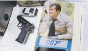  ??  ?? Non-firing James Bond gun replica and autograph of Roger Moore