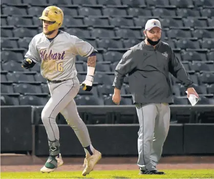  ?? ANDY LAVALLEY/POST-TRIBUNE ?? Hobart’s Jaden Deel, left, passes coach Bob Glover Jr. as he rounds third base after hitting a home run that put the Brickies up 3-2 during a game against Highland.