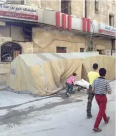  ?? ZAHER SAHLOUL PHOTO ?? Makeshift decontamin­ation tents outside an Aleppo hospital, where doctors wash off victims of suspected chemical weapon attacks.