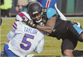  ?? AP PHOTO ?? HARD KNOCK: Jaguars defensive end Yannick Ngakoue slams Bills quarterbac­k Tyrod Taylor to the turf during yesterday’s game.