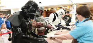  ?? Photo courtesy Fáilte Ireland Photo Valerie O’Sullivan. ?? (Left) Bounty Hunter Boba Fett accompanie­d by some Storm Troopers sample the sweets at Skellig Chocolates.
(Below) Fett and his allies on Valentia island