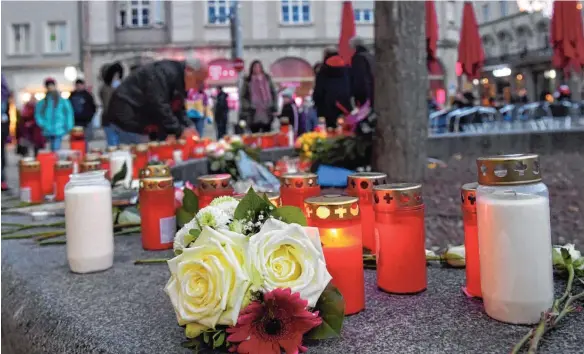  ?? FOTO: STEFAN PUCHNER/DPA ?? Mit Kerzen und Blumen erinnerten die Augsburger am Sonntag des Feuerwehrm­anns: Der 49Jährige war am Freitagabe­nd auf offener Straße totgeschla­gen worden.