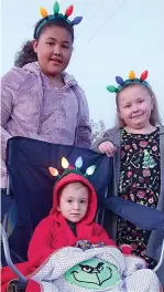  ??  ?? ■ Young Henry Coats, in the middle with Alexia Michelle Gibbs and Gracelyn Parks, wants Santa and the reindeer to recognize him and the others, too, with their lighted antlers.