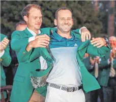  ?? FOTO: DPA ?? Sitzt, passt, wackelt und hat Luft: Vorjahress­ieger Danny Willett hilft Sergio Garcia ins Grüne Jackett des Siegers.