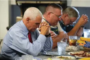  ?? The Associated Press ?? Republican presidenti­al candidate and former Vice President Mike Pence prays before lunch during a stop at the Indiana State Fair Wednesday in Indianapol­is.