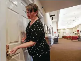  ??  ?? Amy Maldonado disinfects door handles Monday at Carnes Funeral Home, which has changed some practices to protect workers from the coronaviru­s.