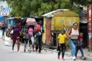  ?? Photograph: Ralph Tedy Erol/Reuters ?? Residents flee their homes after gun-battles between rival gangs in Port-au-Prince.