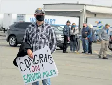  ?? AUSTIN FLESKES / Loveland Weekly ?? Kelly Greeno hold a congratula­tions sign at the Walmart Distributi­on Center in Loveland Wednesday to greet his father, Warren Greeno, the first Walmart long-distance truck driver to reach 5 million safe miles.