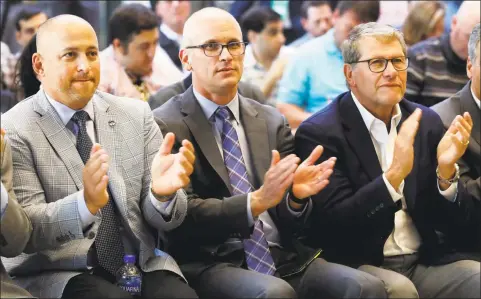  ?? Richard Drew / Associated Press ?? UConn Director of Athletics David Benedict, left, men’s basketball coach Dan Hurley, center, and women’s basketball coach Geno Auriemma applaud in 2019 during the announceme­nt that the Huskies are re-joining the Big East Conference.