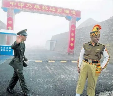  ?? Diptendu Dutta AFP/Getty Images ?? CHINESE AND INDIAN soldiers stand at a border crossing in northeaste­rn India’s Sikkim state in July 2008. China and India are increasing­ly confident players in a battle for supremacy in southern Asia.