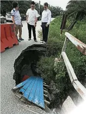  ??  ?? ▲梁自堅（右）巡視土崩路段，並呼籲居民勿使用該道­路，以策安全。左起為顏貝倪及蔡偉傑。右圖為羅里放緩車速，小心翼翼經過土崩路段。