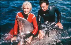  ??  ?? TOP: Valerie watching sharks, inside the safety of a cage. ABOVE: With Ron taking the temperatur­e of a great white shark that had been entangled in a steel trace.