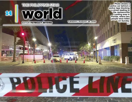  ??  ?? Photo shows a police car behind a police tape blocking a street leading to the Jacksonvil­le Landing area in Florida, where two people were killed on Sunday. AFP