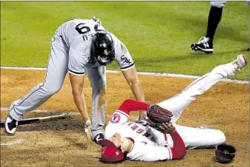  ?? Ashley Landis Associated Press ?? ANGELS PITCHER Shohei Ohtani is checked on by the White Sox’s José Abreu after they collided at home plate in the fifth inning Sunday night. The Angels removed Ohtani from the game, but he said he isn’t injured.