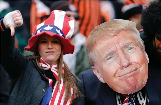  ??  ?? A fan gives a thumbs-down alongside a likeness of US President Donald Trump in the stands during a game last year.