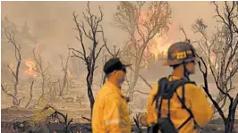  ?? MARCIO JOSE SANCHEZ/AP ?? Members of the San Bernardino County Fire Department keep an eye on a flare-up from the Bobcat Fire on Saturday in Valyermo, California. The wildfire started Sept. 6.