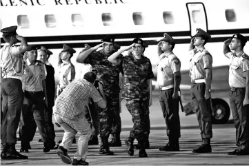  ??  ?? Mitretodis and Dimitris Kouklatzis salute a guard of honor after being released, at the airport of Thessaloni­ki, Greece. — Reuters photo