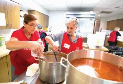  ?? Staff photo by Evan Lewis ?? Donna Milward and Sue Lambert make a pot of soup Thursday during the Stone Soup Luncheon sponsored by The Salvation Army’s Women’s Auxiliary at First United Methodist Church in Texarkana, Ark. The Women’s Auxiliary has been holding the annual...
