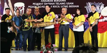  ??  ?? Jok (third left) presents a sape as memento to Dennis (fourth right) as Charles (third right) and others look on.